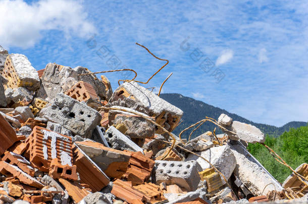 蓝天下建筑工地上堆积如山的碎石、破碎的砖块和砖块