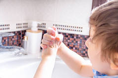 可爱的小男孩用肥皂洗手。清洁及卫生概念.