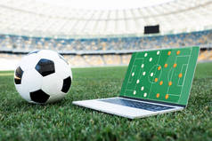 体育场草地足球场屏幕上有队形的足球和笔记本电脑