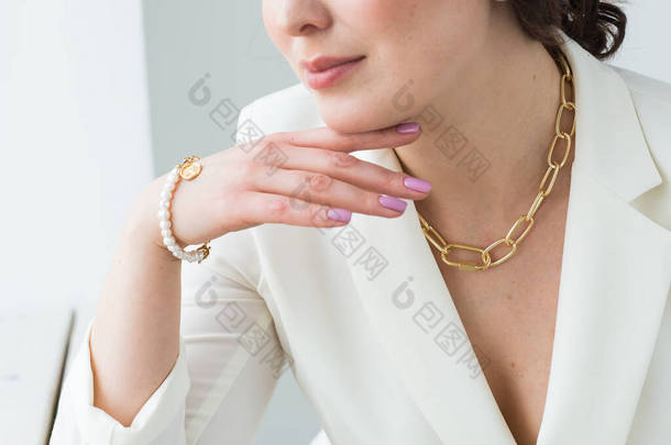 一个戴着金项链和手镯的女人的特写。珠宝、 Bijouterie和配件概念.