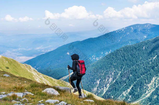 背负着背包的远足妇女<strong>站在</strong>有着令人惊叹的景色的<strong>山顶</strong>上。保加利亚皮林山
