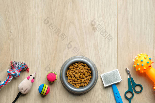 宠物护理和训练的概念。在木制桌子上摆满了干粮和猫狗饰品的碗。平躺在地上，尽收眼底。兽医商店的横幅模型.