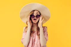 一个头戴夏帽、戴着太阳镜、身披黄褐色背景的震惊而又体贴的年轻貌美女子