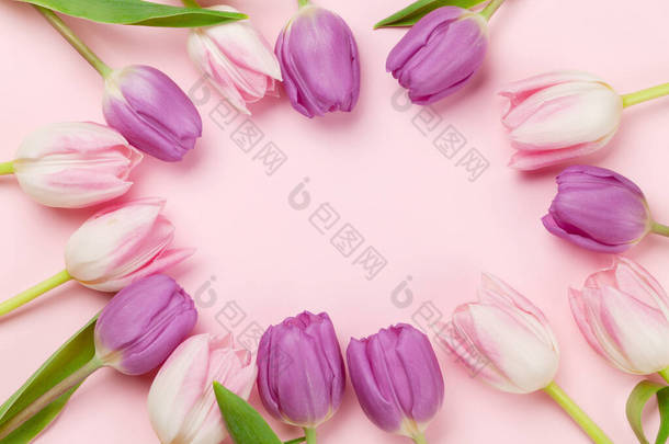 粉红的郁金香花覆盖在粉红色的背景上.带有复制空间的贺卡模板