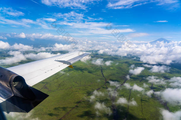 在坦桑尼亚、东非的上空和云层之上飞行。<strong>飞机</strong>的窗户视图。<strong>飞机</strong>在<strong>地球</strong>上方的天空中飞行.