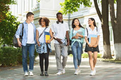 学生交流。一群大学生朋友在大学校园里散步