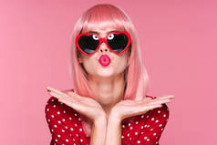 身穿粉色假发、戴着太阳镜的年轻漂亮女子站在演播室里
