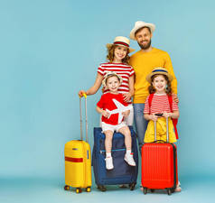 全身上下幸福的父母和孩子们，背着行李，面带微笑，面对着蓝色的背风镜头