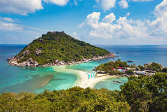 Scenic shot of green mountains edged by turquoise and blue sea