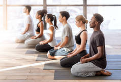 健康概念。瑜伽课上年轻的运动员一起进行冥想练习