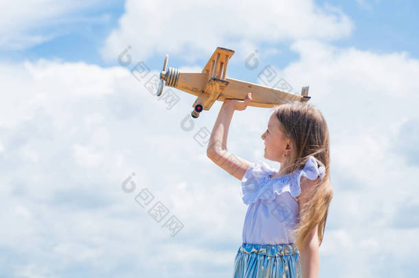 坐飞机旅行。继续做梦小孩玩木制玩具飞机。学习地理。关于旅行的梦想。暑假的故事。小女孩拿着木制的飞机。想象力
