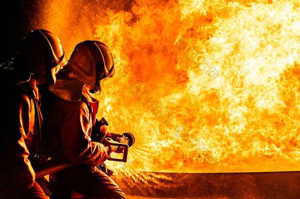消防员使用旋翼水雾式<strong>灭火</strong>器与油火<strong>灭火</strong>，以控制火势的蔓延。消防员和工业安全概念.