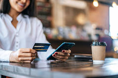 在咖啡店用智能手机用信用卡支付货款.