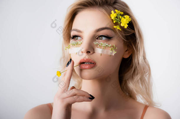 美丽的金发女人，眼皮底下长着野花，嘴上被白色隔离着