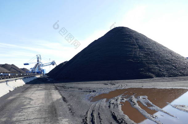 在港口的<strong>煤炭</strong>终端上有一个开放的<strong>煤炭</strong>仓库。一个堆栈回收器正在后台工作.