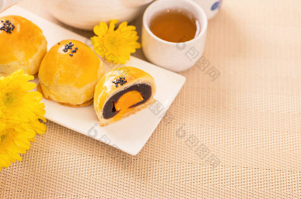 <strong>中秋节</strong>烤鸡蛋蛋黄糕点月饼，色泽鲜亮，餐桌背景明亮。中国节庆食品的概念，闭合，复制空间.