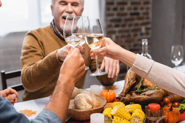 <strong>感恩节大</strong>餐期间，一家人在酒杯中碰杯白葡萄酒