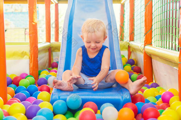 小孩儿在儿童娱乐场所玩球和享受时光的肖像。快乐的孩子带着彩色气球在幼儿园玩耍.