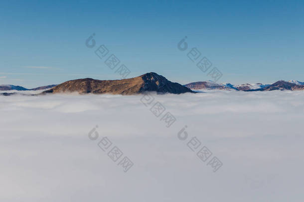冬天的一天，在喀尔巴阡山脉的云彩之上，云雾笼罩在山顶上的山谷阳光。在云彩之上
