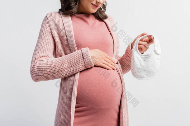 孕妇抱着用白色隔离的小婴儿围裙的剪影