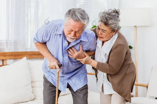 年事已高的亚洲退休老年丈夫患有心脏病或严重或忧心忡忡的妻子在家照顾自己。医疗急救和医疗保险保护概念