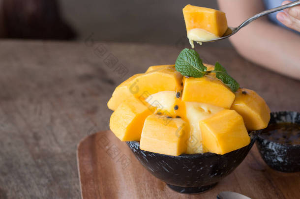 在木制桌子上的陶瓷碗里重新装饰芒果<strong>冰激凌</strong>和西番莲水果，作为<strong>夏天</strong>最受欢迎的甜点.