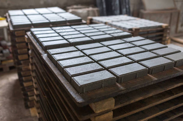 用压实水泥砂浆进行建筑材料工业生产.优质水泥制成的优质铺路石。压印后，成品堆放在干燥无味的货盘上.