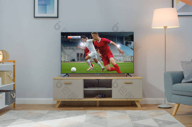 用足球赛拍的电视。舒适明亮的客厅，椅子和灯在家里打开.
