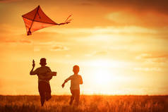 日落时孩子们在田野里放风筝
