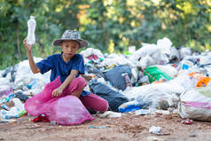 一个从垃圾填埋场收集垃圾的穷小子贫困儿童的生计概念。童工。童工、贩运人口、贫穷概念