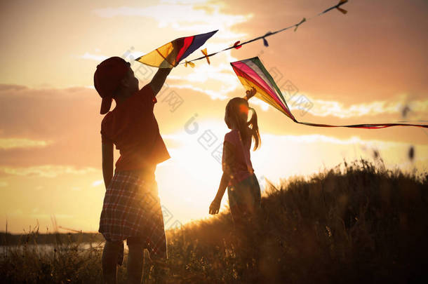 日落时，小孩子们在户外玩风筝。在性质上花费的时间