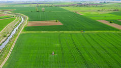 空中观察牵引机在绿色的大田野上喷洒化学药品.把除草剂喷在农田上.作物抗杂草处理.