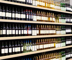 酒瓶放在架子上.超级市场内部货架上的红色和白色葡萄酒瓶。3D渲染适用于提供新的葡萄酒瓶和新的品牌标签等.
