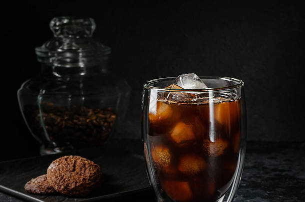 一杯美式咖啡，在深色石头的背景上装上冰块。夏日清爽饮料.