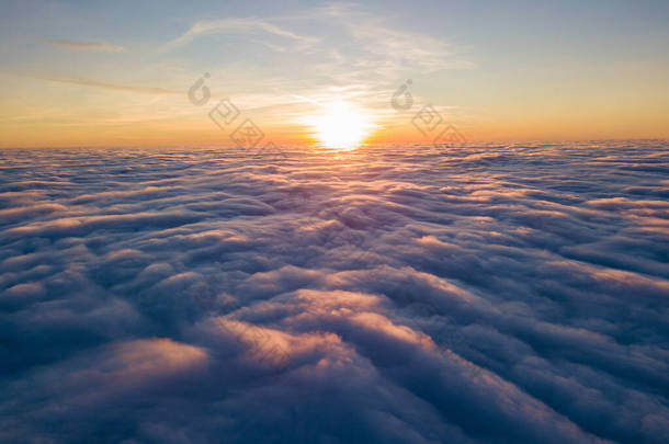 落日笼罩在卷曲的云彩之上，空中高空飞行。最后一缕阳光照射在云彩上.