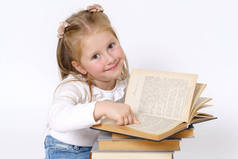教育和人的概念。一个少女的画像，她坐在书本旁边，阅读和看着摄像机。在白色背景下被隔离.