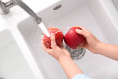女人们在厨房水槽里洗鲜红的苹果，俯瞰