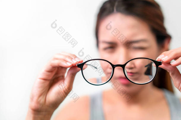 持有白色背景眼镜的亚洲女性，选择性聚焦眼镜、<strong>近视眼</strong>及视力问题概念.