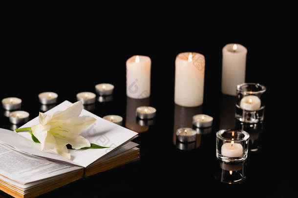 百合花，蜡烛和圣经黑色<strong>背景</strong>，<strong>葬礼</strong>的概念