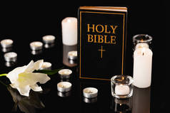 百合花，蜡烛和圣经黑色背景，葬礼的概念