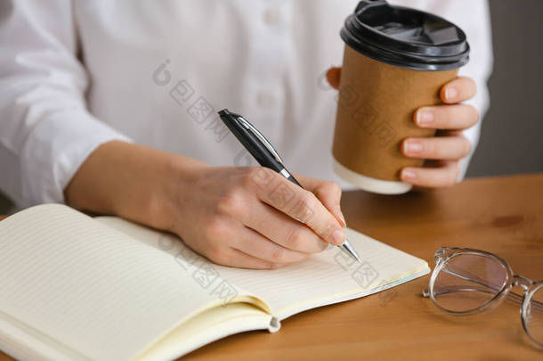 女人用笔在笔记本上写字