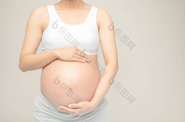 怀孕的女人摸她的大肚子。<strong>靠近点</strong>母亲、怀孕、人和期望的概念。怀孕妇女怀孕分娩