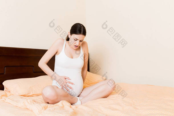 年轻漂亮的孕妇痛苦不堪，躺在床上准备<strong>生孩子</strong>.