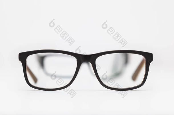 两副眼镜放在白色的表面上.最接近的被聚焦在<strong>焦点</strong>上，而其他的被看穿了头一个，并且失去了<strong>焦点</strong>。背景是白色的.