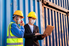 团队合作，亚洲男性物流仓库领班与员工一起使用笔记本电脑检查清单的规划和策略从货轮集装箱箱。工业进出口航运业务.