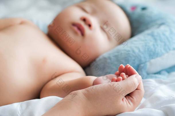 有选择性地将小宝宝放在妈妈的手里，紧靠在床上，新的家庭和宝宝免受妈妈的影响概念