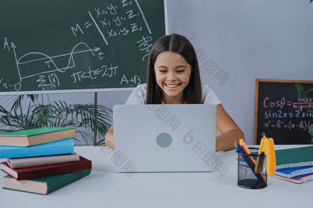 <strong>快乐</strong>的女学生一边微笑着一边<strong>上网</strong>学习和看笔记本电脑