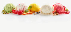 一套不同颜色的冰淇淋勺，带有水果、浆果和坚果装饰，背景白色，有复制空间