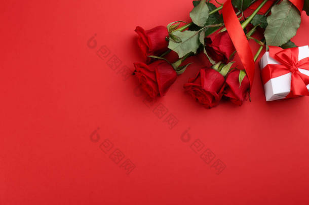 美丽的玫瑰和礼品盒在红色的背景上,平坦的放置与文字的空间.<strong>情人节</strong>庆祝<strong>活动</strong>