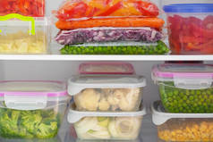 冰箱内装有蔬菜的集装箱和塑料袋，特写镜头